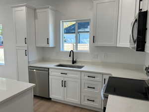 Kitchen with appliances with stainless steel finishes, white cabinetry, and plenty of natural light