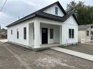 View of front facade featuring board and batten siding, a porch, and a shingled roof