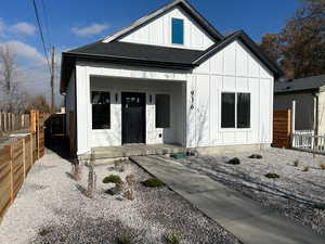 View of front of home featuring board and batten siding, covered porch, and a shingled roof
