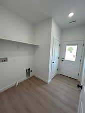 Laundry area featuring light wood-type flooring, hookup for a gas dryer, and washer hookup