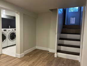 Washroom featuring wood finished floors and separate washer and dryer