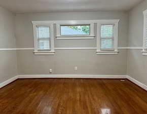 Unfurnished room featuring dark wood finished floors and baseboards
