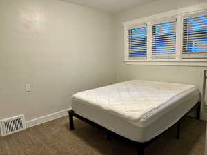 Bedroom featuring dark carpet and baseboards