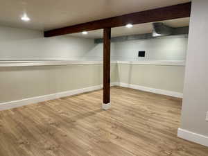 Finished below grade area featuring recessed lighting and light wood-style flooring