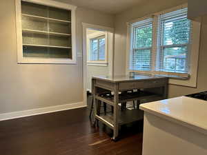 Dining space featuring baseboards and dark wood-style floors