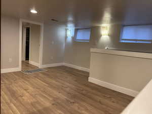 Basement with wood finished floors and recessed lighting