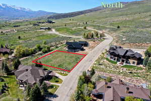 Aerial view of property's location with property boundaries highlighted and a mountain backdrop