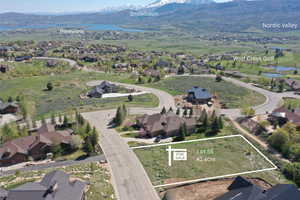 Aerial perspective of suburban area with a water and mountain view and property parcel outlined