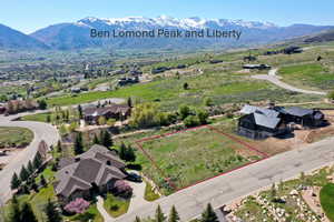 Aerial view of property and surrounding area featuring mountains and property parcel outlined