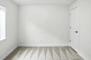 Carpeted empty room with baseboards