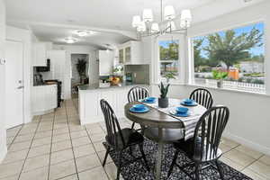 Dining area featuring light tile patterned floors and a chandelier