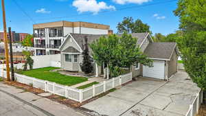 View of front of home featuring roof with shingles, a fenced front yard, driveway, and an attached garage