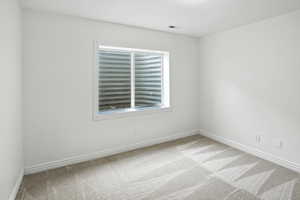 Carpeted spare room with baseboards