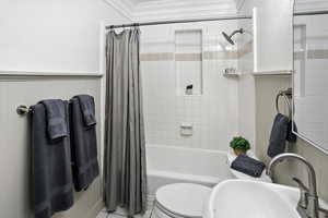 Full bath featuring shower / tub combo with curtain, tile patterned flooring, and crown molding