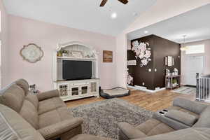 Living area with light wood finished floors, a ceiling fan, vaulted ceiling, and recessed lighting