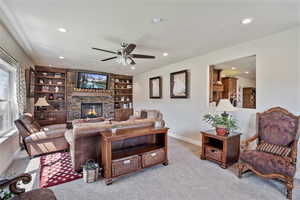 Living area with carpet flooring, built in features, ceiling fan, recessed lighting, and a fireplace