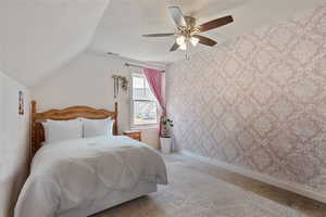 Bedroom with carpet floors, wallpapered walls, a textured ceiling, ceiling fan, and lofted ceiling
