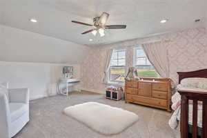 Carpeted bedroom with a textured ceiling, a ceiling fan, wallpapered walls, and recessed lighting