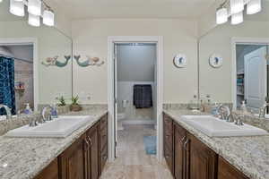 Bathroom with two vanities, a shower with shower curtain, and light tile patterned floors