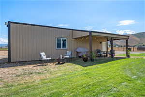 Back of property with a mountain view and a patio