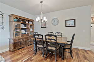 Dining space with light wood finished floors and a chandelier