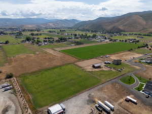 Aerial view of sparsely populated area featuring a mountainous background and abundant farmland