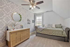 Bedroom featuring wallpapered walls, carpet, a textured ceiling, and ceiling fan