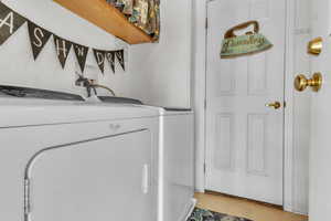 Washroom with washer and clothes dryer and light tile patterned flooring