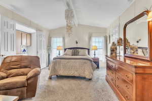 Bedroom with light carpet, multiple windows, vaulted ceiling, and crown molding