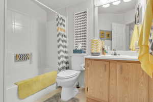 Bathroom with shower / bathtub combination with curtain, vanity, and light tile patterned flooring