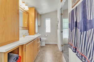 Bathroom featuring wallpapered walls and vanity
