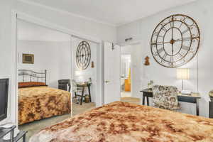 Bedroom with light carpet and a closet