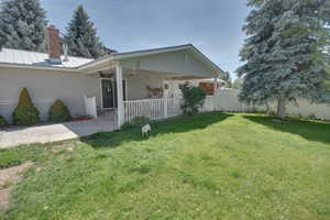 Rear view of property featuring a ceiling fan, a metal roof, a patio, a chimney, and a standing seam roof