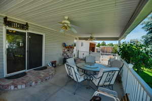 View of patio with outdoor dining area and ceiling fan