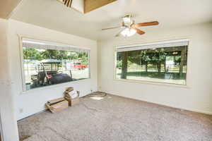Carpeted empty room featuring baseboards and a ceiling fan