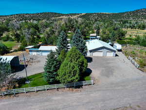 View from above of property featuring a heavily wooded area and a mountainous background