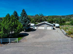View of front of house with an outbuilding and gravel driveway