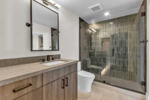 Bathroom featuring vanity, a stall shower, light tile patterned floors, and recessed lighting