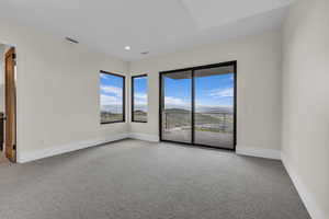 Empty room with light colored carpet, a mountain view, and recessed lighting