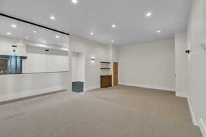 Empty room with recessed lighting and light colored carpet