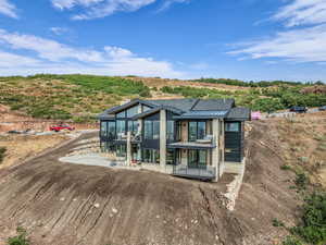 Rear view of house featuring a sunroom, a standing seam roof, a patio area, and a metal roof