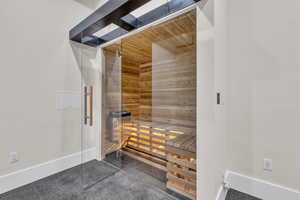 Relaxing sauna featuring tile patterned floors and wooden walls