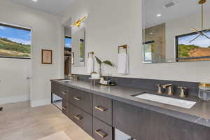 Full bathroom with double vanity, a stall shower, recessed lighting, and healthy amount of natural light