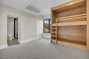 Unfurnished bedroom with carpet floors, recessed lighting, and ensuite bath