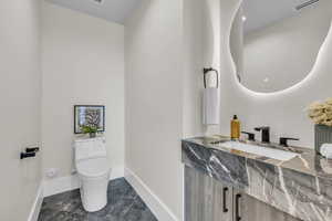 Half bath featuring baseboards and toilet