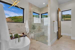 Full bath featuring a freestanding tub, a marble finish shower, healthy amount of natural light, and recessed lighting