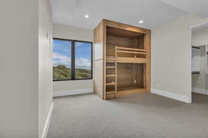 Unfurnished bedroom featuring light carpet, recessed lighting, and a sauna