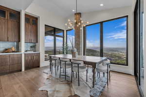 Dining space with vaulted ceiling, light wood-style flooring, a chandelier, recessed lighting, and a water and mountain view