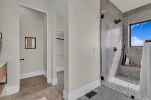 Bathroom featuring a stall shower and a spacious closet