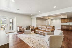 Living area featuring french doors, recessed lighting, dark wood-style flooring, and a raised ceiling
